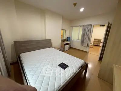 Spacious bedroom with modern wooden furniture and large window for natural light.