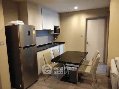 Modern kitchen and dining area with sleek appliances and stylish furniture in a contemporary apartment.
