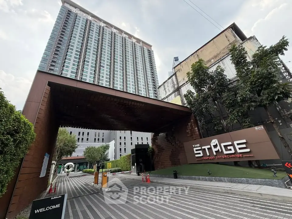 Modern high-rise building entrance with sleek design and lush greenery