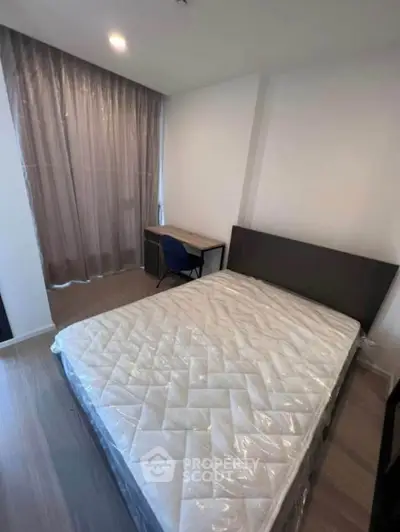 Cozy bedroom with a large bed and study desk, perfect for restful nights and productive days.