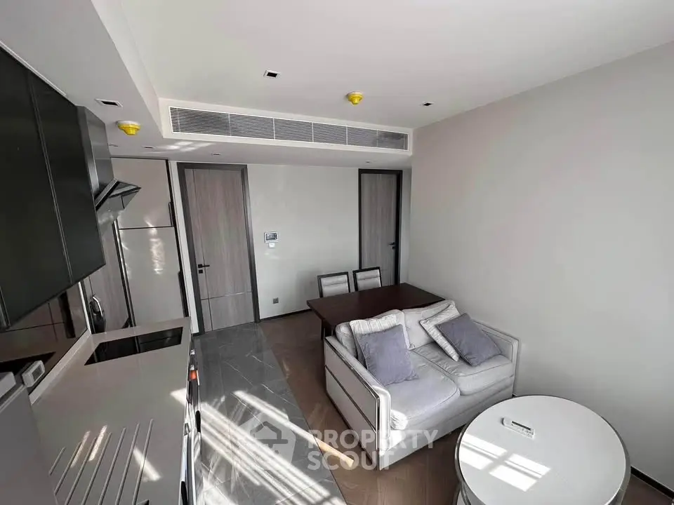 Modern living room with sleek furniture and open kitchen layout, perfect for urban living.