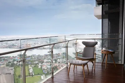Stunning high-rise balcony with panoramic city and river views, perfect for relaxation.