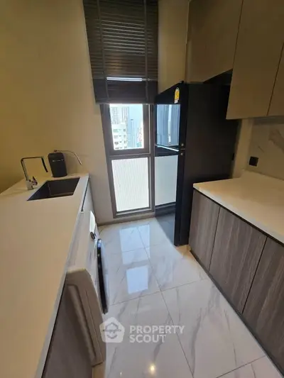Modern kitchen with sleek cabinetry and city view window