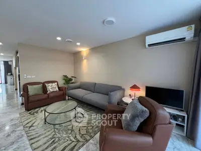 Spacious modern living room with elegant furniture and air conditioning, perfect for relaxation.