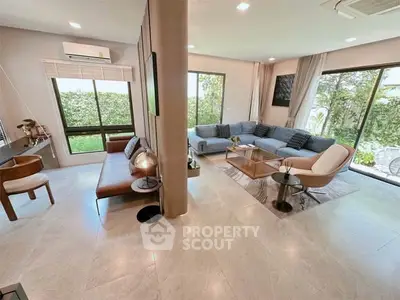 Spacious modern living room with large windows and stylish furniture, perfect for relaxation and entertaining.