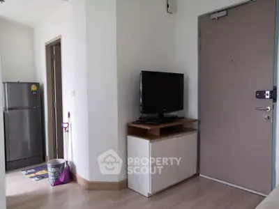 Modern apartment entryway with TV and refrigerator