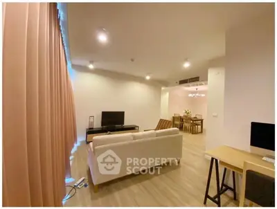 Spacious modern living room with elegant decor and dining area, perfect for comfortable living.