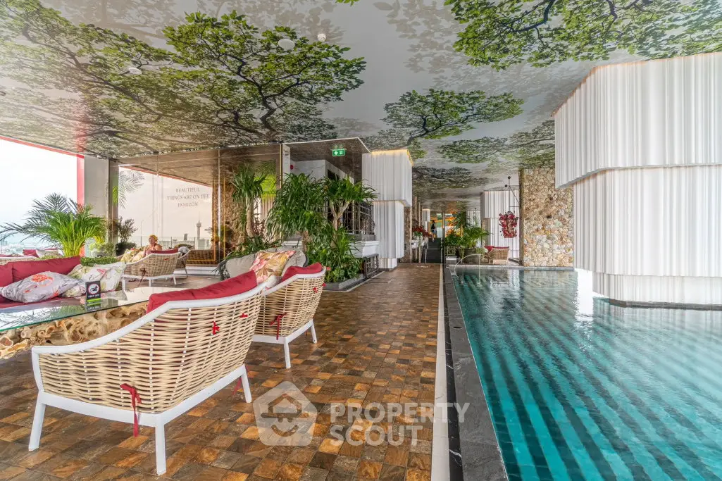 Luxurious indoor pool area with stylish seating and nature-themed decor, perfect for relaxation and leisure.