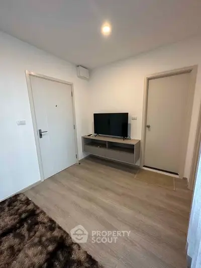 Modern living room with sleek TV stand and cozy rug, perfect for relaxation.