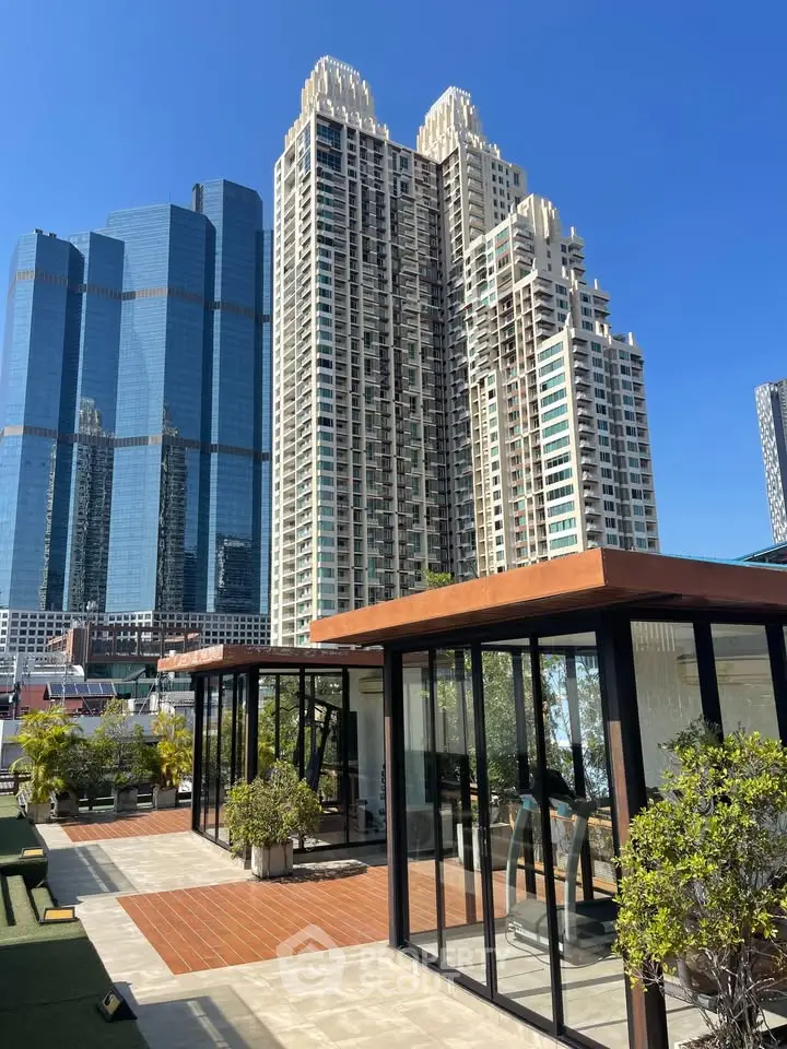 Stunning rooftop view with modern glass gym and towering skyscrapers in the background.