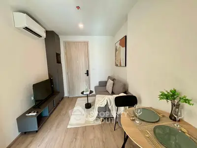 Modern living room with cozy sofa, TV, and dining area in stylish apartment.