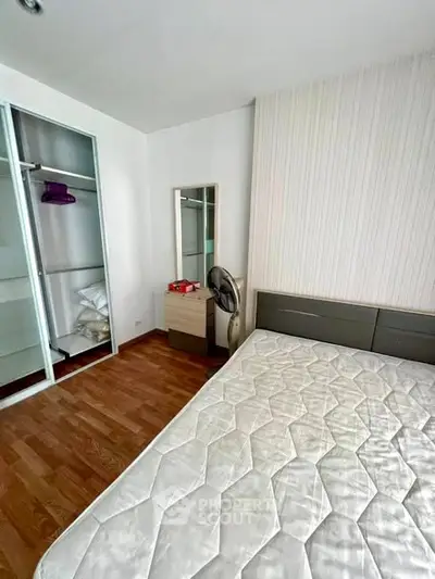 Spacious bedroom with wooden flooring and built-in closet, perfect for modern living.