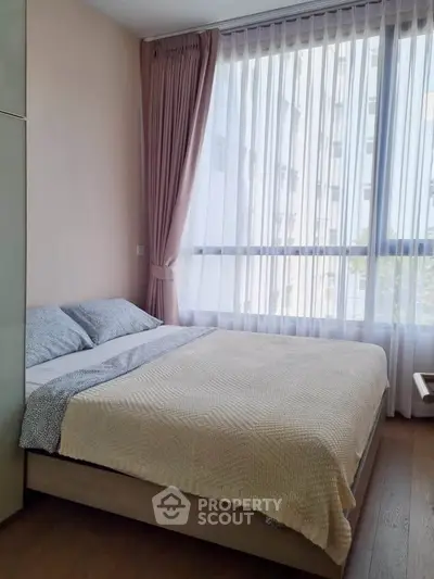 Cozy bedroom with large window and elegant curtains in modern apartment.