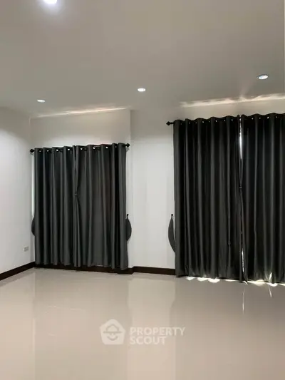 Spacious empty room with elegant dark curtains and glossy tiled floor, perfect for customization.