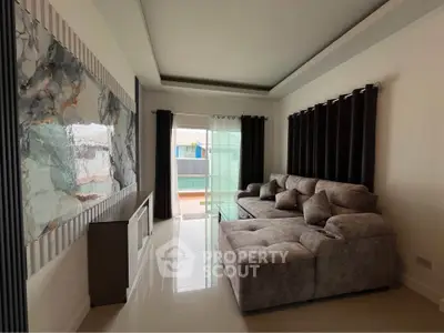 Modern living room with stylish sectional sofa and elegant wall art, featuring large windows for natural light.