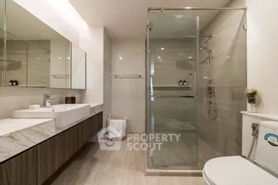 Luxurious modern bathroom with glass shower and elegant marble countertop.