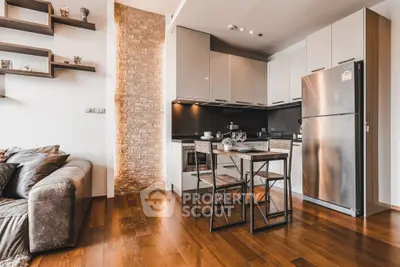 Modern open-layout kitchen with sleek appliances and cozy dining area in stylish apartment.
