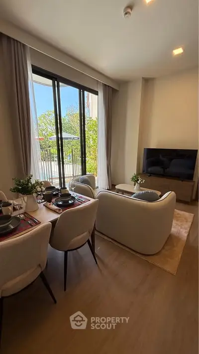 Modern living room with elegant dining area and large windows opening to a balcony with a view.