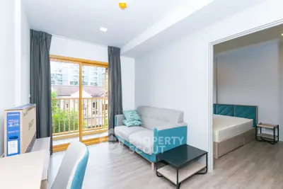 Modern living room with balcony view and stylish furniture in a cozy apartment.