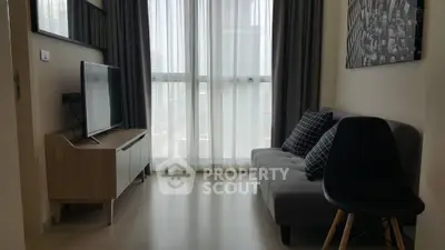 Modern living room with sleek furniture and large window, perfect for urban living.