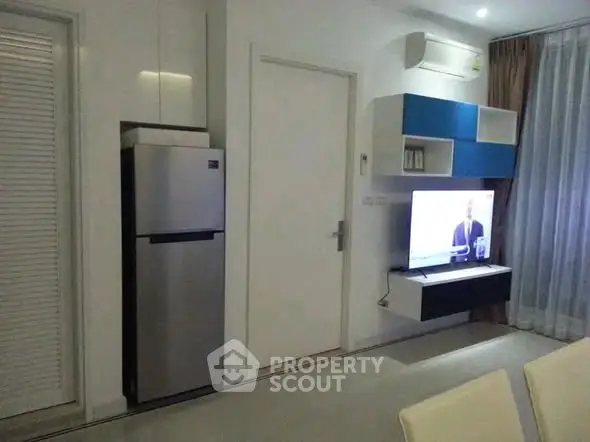 Modern living room with sleek furniture and wall-mounted TV in a stylish apartment.