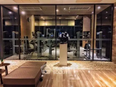 Luxurious gym with modern equipment and stylish interior design in upscale residential building.