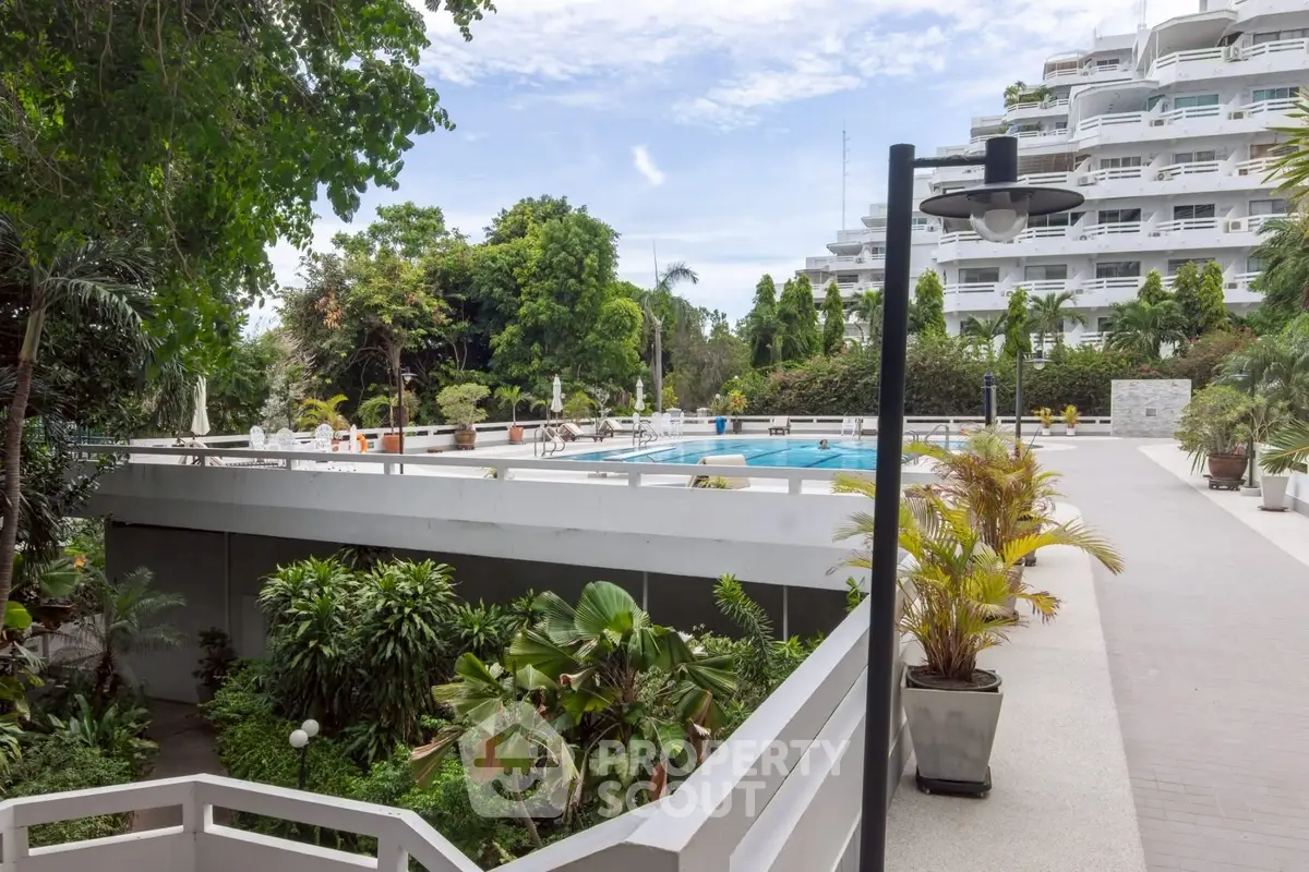 Luxurious condominium with lush greenery and inviting pool area, perfect for relaxation and leisure.