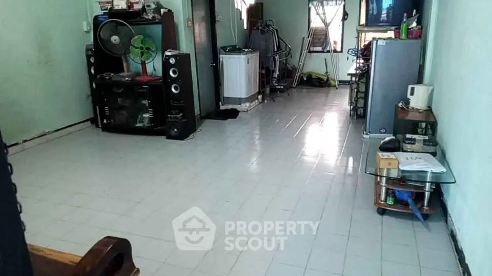 Spacious living area with tiled flooring and essential appliances, ideal for comfortable living.