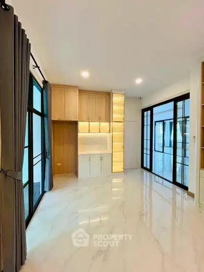 Spacious modern living room with elegant marble flooring and large windows for natural light.