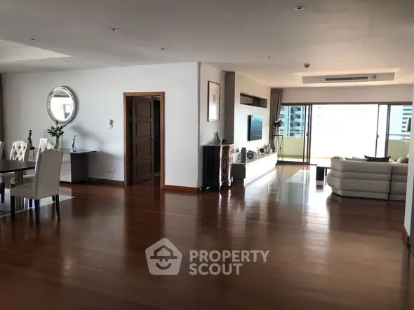 Spacious open-plan living room with elegant decor and large balcony access.