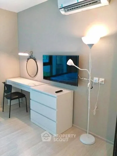 Modern study area with sleek desk, wall-mounted TV, and stylish lighting in a contemporary apartment.