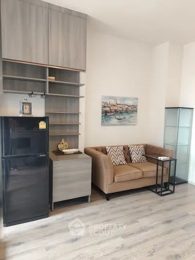 Modern living room with stylish sofa, sleek fridge, and elegant shelving.