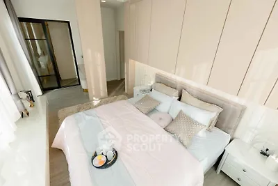 Luxurious bedroom with elegant decor and natural light, featuring a cozy bed and stylish furnishings.