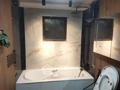 Modern bathroom with bathtub and elegant marble tiles