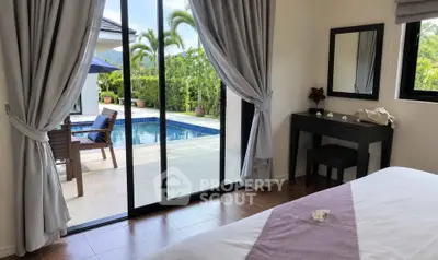 Luxurious bedroom with pool view and elegant decor, perfect for relaxation.