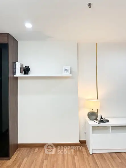 Modern minimalist living room with wooden flooring and sleek furniture design.