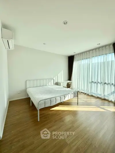 Bright and airy bedroom with large windows and minimalist decor