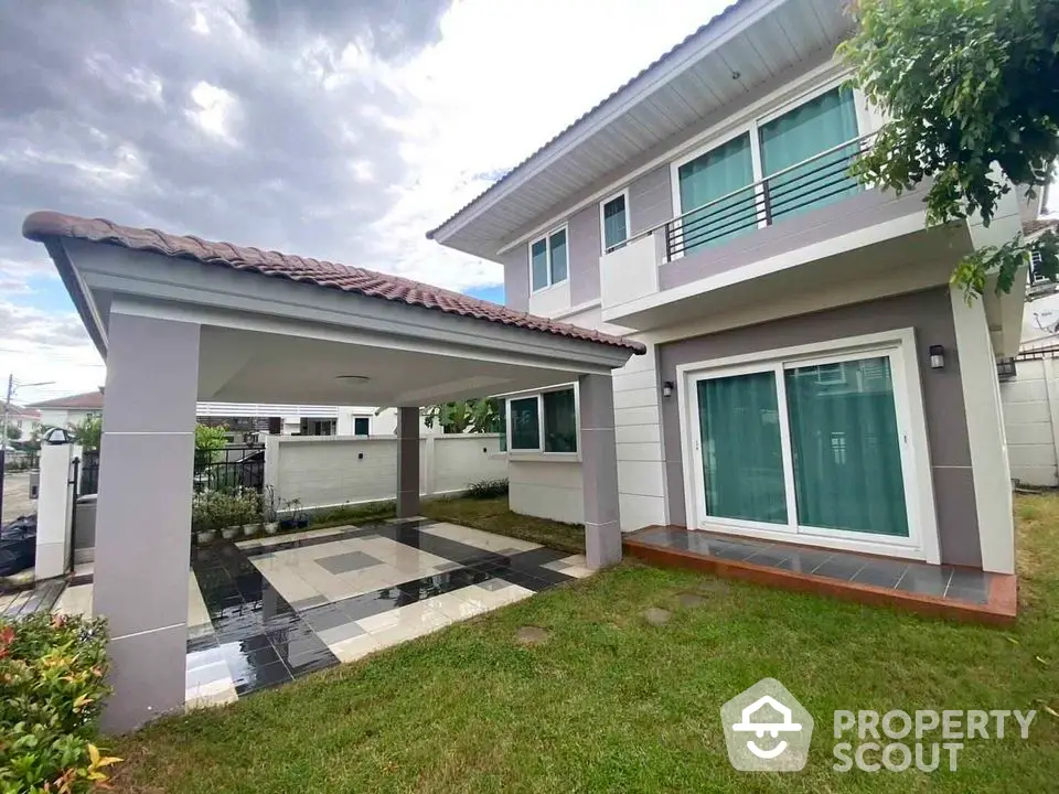 Modern two-story house with spacious carport and lush green lawn