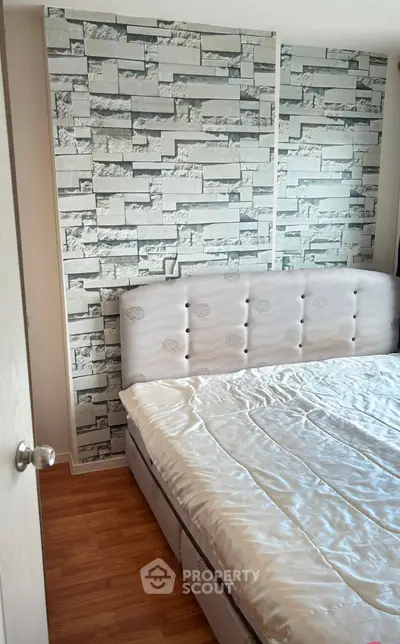 Modern bedroom with stylish stone accent wall and cozy bed setup