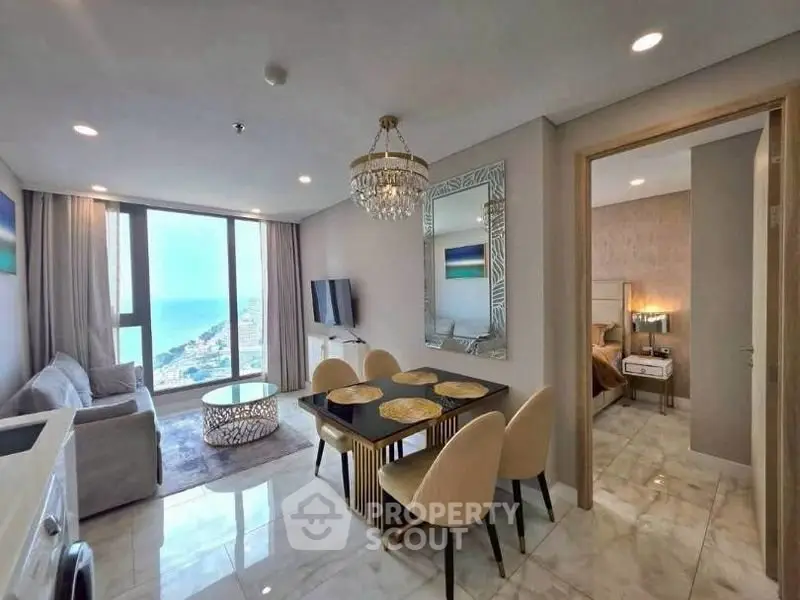 Luxurious modern living room with ocean view, elegant dining area, and stylish decor in a high-rise apartment.