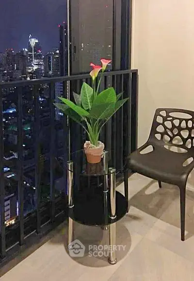 Chic balcony with city skyline view, modern chair, and stylish plant stand for urban living.