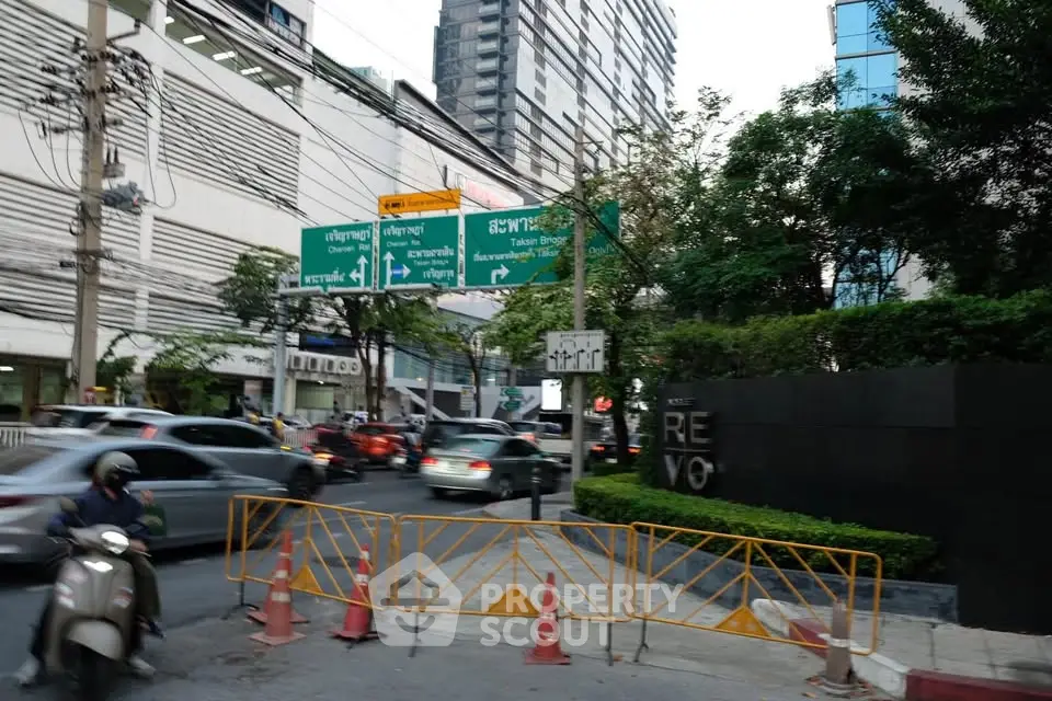Bustling city street view with modern high-rise buildings and traffic in urban setting.