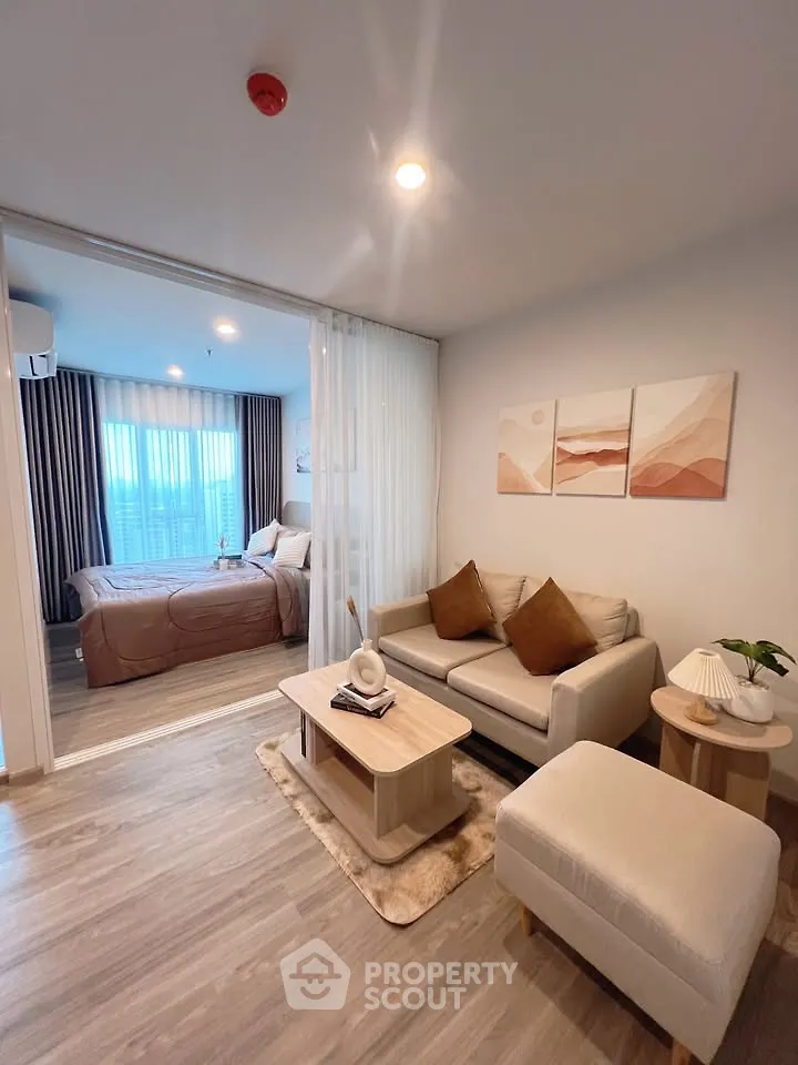 Modern living room with cozy seating and stylish decor adjacent to a chic bedroom.