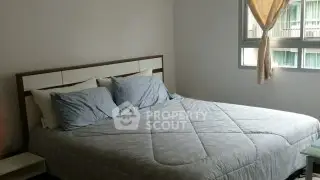 Cozy bedroom with large bed and natural light from window, perfect for relaxation.