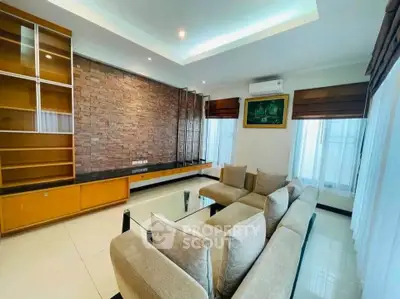 Spacious modern living room with stylish brick accent wall and cozy seating area.