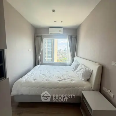 Modern bedroom with city view and cozy bedding in high-rise apartment