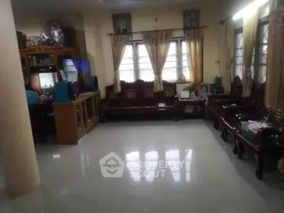 Spacious living room with elegant wooden furniture and large windows for natural light.