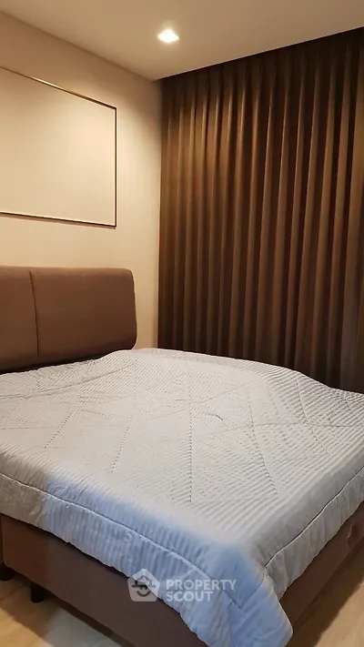 Cozy bedroom with modern decor and elegant curtains, perfect for relaxation.