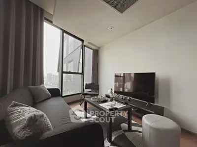 Modern living room with sleek furniture and large windows offering city views.