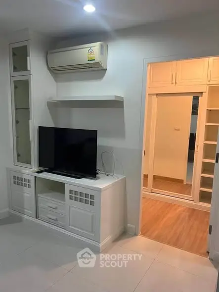 Modern living room with built-in TV cabinet and air conditioning unit.